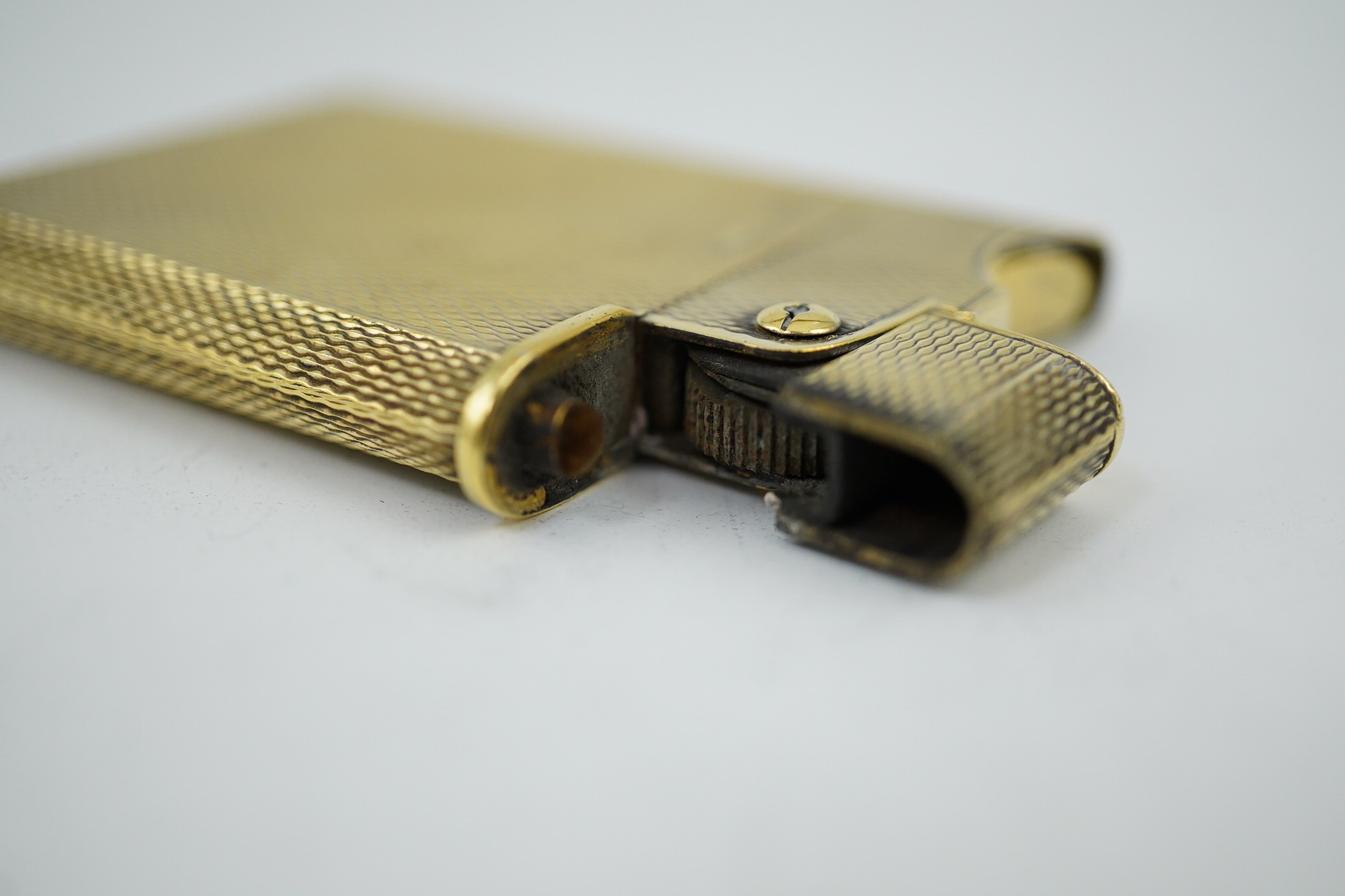 An Elizabeth II Asprey & Co engine turned silver gilt 'wafer' lighter